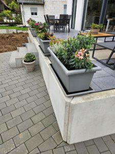 Außenanlage Terrasse mit L-Steinen, Blockstufen und grauen Betonplatten