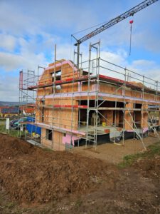 Rohbau für ein Einfamilienhaus mit Giebeln und großen Fensteröffnungen aus Porotonsteinen